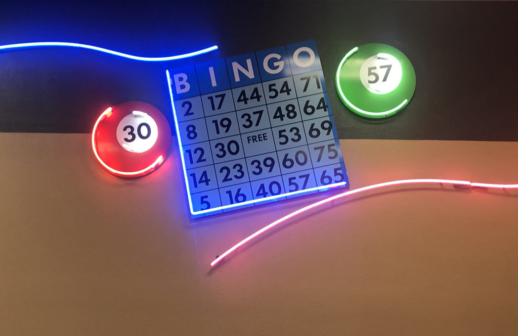Large neon sign of a bingo card on the wall